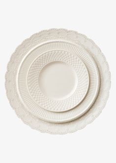 three white plates stacked on top of each other in the shape of an intricate design