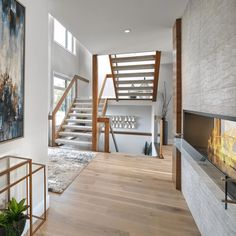 a living room filled with furniture and a fire place next to a stair case in front of a painting on the wall