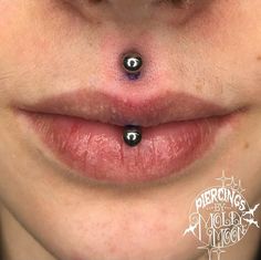 a woman with two piercings on her lip and nose is looking at the camera