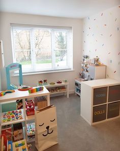 a child's playroom with toys, bookshelves and storage bins