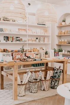 a table with baskets and books on it in a room that has shelves full of books