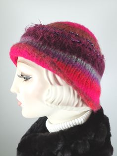 Add some warmth and whimsy to your fall and winter wardrobe with this fun hand knitted boiled and felted 100 percent wool warm winter cloche. This cute wool hat will keep you warm! Dress it up with an oversize shawl or throw it on with a jean jacket. Colors include fuchsia pink, rust and blue with other colorful fun fibers that pop out of the felt for added texture. Embellished with two handmade silk rosettes topped with iridescent vintage glass buttons. Rolled asymmetrical brim for additional i Whimsical Winter Hat With Short Brim, Multicolor Winter Cloche Hat With Short Brim, Multicolor Winter Cloche Hat With Curved Brim, Multicolor Curved Brim Cloche Hat For Winter, Winter Wool Mini Hats, Pink Fitted Winter Hat, Whimsical Red Winter Hat, Purple Whimsical Winter Hat, Whimsical Purple Winter Hat