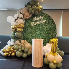 a birthday cake with balloons and greenery in the shape of a number one on it