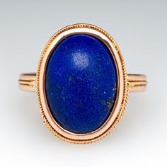 This distinctive ring features a bezel set oval cabochon lapis lazuli and delicate twisted rope design around the bezel and band. It is crafted in 14k yellow gold with a light patina. This ring is currently a size 7.25. Part of the twisted bezel detail is missing but this does not take away from the charm of the ring. Oval Lapis Lazuli Rings For Formal Occasions, Formal Lapis Lazuli Oval Rings, Lapis Lazuli Ring, Rope Design, Oval Cabochon, Bezel Setting, Lapis Lazuli, Patina, Yellow Gold