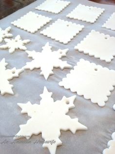 snowflake cookies on a baking sheet ready to be cut and decorated for christmas