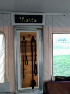 the inside of a train car with two doors open and several leashes hanging on the wall