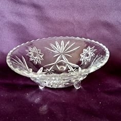 a glass bowl sitting on top of a purple cloth