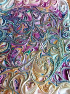 an abstract painting made out of paper with swirls and colors on it's surface