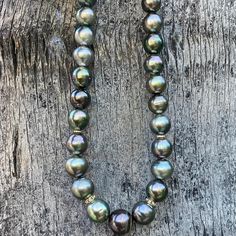 This stunning "black" Tahitian Pearl Necklace is made with vivid, multi colored Pearls that have a beautiful high luster. The Pearls are pretty round but not perfect. The necklace is adorned with diamond spacer beads and finished off with a vermeil diamond lobster clasp. Charms can be added to the sparkly clasp if desired. The Pearls have an overtone of silver/grey, peacock and aubergine. There are some small blemishes on a few pearls. This is a classic and elegant piece and the perfect size for High Luster Tahitian Pearl Necklace, Tahitian Pearl Necklace With Round Beads, Elegant Iridescent Round Bead Necklaces, Elegant Iridescent Necklace With Round Beads, Elegant Iridescent Beaded Necklace, Tahitian Pearl Necklace With High Luster Round Beads, High Luster Tahitian Pearl Necklace With Round Beads, Black Tahitian Pearl Round Bead Necklace, Black Tahitian Pearl Necklace With Round Beads