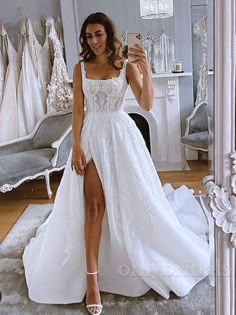 a woman taking a selfie while wearing a wedding dress in front of a mirror