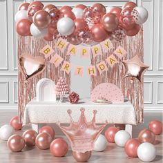 a pink and white birthday party with balloons, streamers, cake and tiara