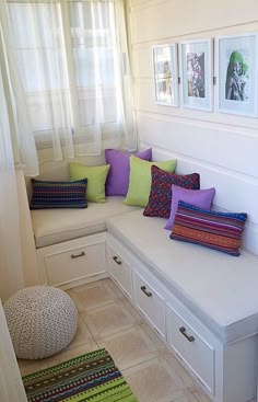 a white bench with lots of pillows on it