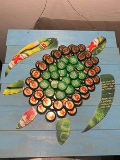 an art project made out of beer bottle caps and wood planks with a turtle on it