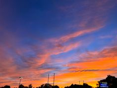 an orange and blue sky at sunset with clouds