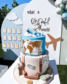 a cake that is sitting on top of a table with an airplane and clouds in the background