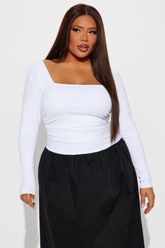 a woman wearing a white top and black skirt