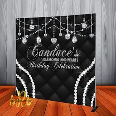 a black and white birthday card with pearls on the strings, diamonds and pearls are hanging from