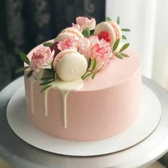 a pink cake decorated with flowers and icing