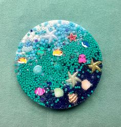 a blue and white plate covered in lots of sea creatures on top of a green surface