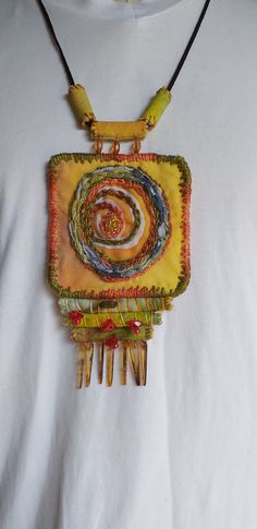 a yellow necklace with an abstract design on it