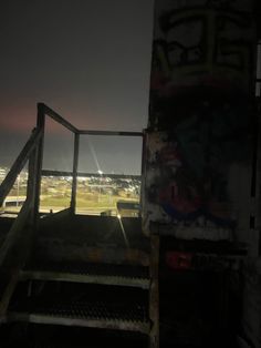 a stairway leading to the top of a building with graffiti all over it at night