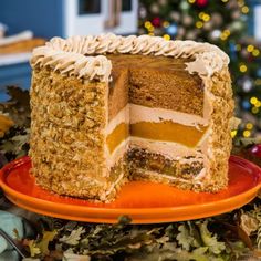 a cake sitting on top of an orange plate next to a christmas tree with lights