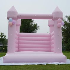 an inflatable arch with balloons on the grass