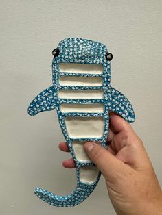 a hand holding a blue and white sea animal