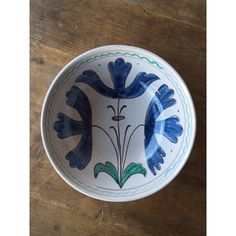 a blue and white bowl sitting on top of a wooden table