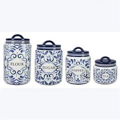 four blue and white canisters with labels on the lids, one has a flower design