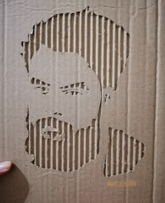 a cardboard cut out of a man's face on top of corrugated paper with stripes