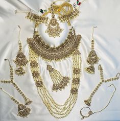 *Adorn yourself with this stunning gold polki jewelry set with pearls for your special day!  *Made with high quality craftsmanship  *10-piece set includes the following: - 1 Large chocker necklace - 1 Long Pearl necklace - 1 Passa - 1 Tikka - 1 Matha patti - 2 Earrings with hair attachment - 2 Hath paan (ring with attached bracelet - 1 Nose ring with chain Matha Patti, Long Pearl Necklaces, Chocker Necklace, 2 Earrings, Polki Jewellery, Engagement Jewelry, Wedding Jewelry Sets, Jewelry Set, Wedding Engagement