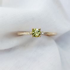 "Solid Gold Peridot Ring With Diamond/ Peridot Engagement Ring/ Promise Ring For Women/ August Birthstone Ring, Textured Round Peridot Ring  Beautiful 9K gold textured band, peridot and diamond engagement ring. The ring features a round 4mm peridot set in a 4 claw prong setting.  Materials: Solid 9ct yellow gold Gemstone: 4mm Peridot Band Width:  1.2mm  Photos of this ring have been taken close up for detail. Please refer to a ruler for dimensions of stone and band width. Don't forget to hit \"favourite\" on the right, so it remains in your favourites list and/ or add to your wish list(s). ------------------------------------------------------------------------------------------------------------------------------------------ Want to find out more? check out our shop https://www.etsy.com/u Diamond And Peridot Ring, Peridot Diamond Ring, Lime Green Diamond Ring With Gemstone, Lime Green Diamond Gemstone Rings, Fine Jewelry Peridot Birthstone Ring With Center Stone, Peridot Diamond Ring For May Birthstone, Yellow Gold Peridot Rings With Gemstone Accents, Green Peridot Birthstone Ring With Prong Setting, Wedding Peridot Diamond Ring In Yellow Gold