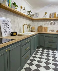 a kitchen with green cabinets and black and white checkered flooring on the walls