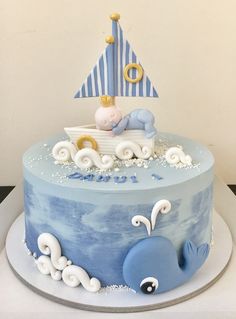 a blue and white cake with a sailboat on top