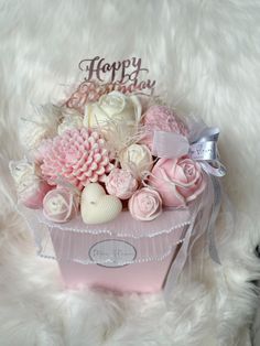 pink and white flowers in a pink box with happy birthday written on the top,