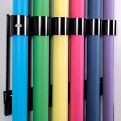 several different colored pens lined up on a wall