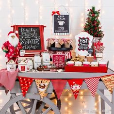 a christmas themed dessert table with santa clause decorations and candy bar wrappers on it