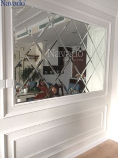 the reflection of a man sitting in a chair is seen through a mirror on the wall