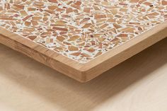 a wooden table topped with lots of brown and white mosaic tiles on top of it