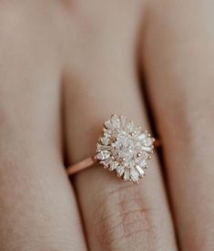 a woman's hand with a diamond ring on top of her finger and an engagement band