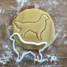 a cookie shaped like a dog on a wooden table