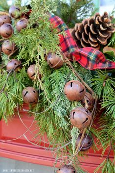 pine cones and evergreen needles are hanging from the top of a red window sill