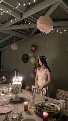 a woman standing in front of a table filled with plates and cake on top of it