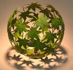 a glass ball with green leaves on it