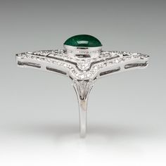 This exquisite ring features a pierced design, centered with an oval, emerald cabochon, weighing 1.75 carats, in a full bezel setting, accented with milgrain details. The top of the ring is accented with one hundred six (106) bead set, round single cut diamonds. The ring measures 31.9mm at the top, rises 8.0mm above the finger, tapering to 1.5mm wide and 0.8mm thick at the base of the shank. This ring is currently a size 5.75. The emerald has surface reaching natural inclusions. Emerald Cabochon, Dinner Ring, Bead Set, Bluish Green, Oval Cabochon, High Quality Jewelry, Bezel Setting, Estate Jewelry, Diamond Shapes