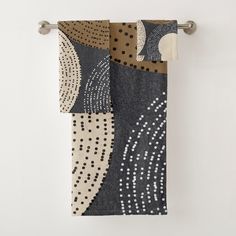 two towels hanging on a towel rack in front of a white wall with polka dots and circles