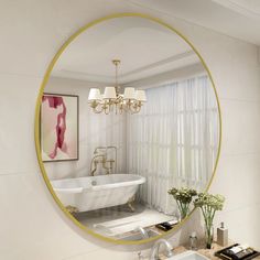 a white bath tub sitting next to a bathroom sink under a large round gold framed mirror