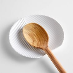 a wooden spoon sitting on top of a white plate