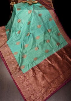 This Pure Tussar Silk Banarasi Saree in greenish cyan is a sublime fusion of tradition and sophistication. The saree, crafted from luxurious tussar silk, showcases the intricate antique zari kadhuwa weaving, renowned for its rich texture and timeless beauty. The greenish cyan hue provides a refreshing and unique twist, setting it apart with a vibrant yet elegant tone. The antique zari work, with its golden shimmer, is meticulously woven into the fabric, creating a stunning visual contrast and enhancing the saree's opulent appeal. Ideal for festive occasions and grand celebrations, this saree embodies regal charm with a modern touch, promising to make a memorable impression with its exquisite craftsmanship and striking color. SILK MARK CERTIFIED This saree is ready to wear with fall and pic Luxury Green Tussar Silk Sets, Luxury Tussar Silk Sets For Women, Elegant Luxury Sets With Zari Weaving, Luxury Silk Fabric With Zari Weaving, Luxury Festive Tussar Silk Set, Luxury Traditional Zari Weaving Fabric, Luxury Tussar Silk Saree With Zari Weaving, Luxury Tussar Silk Traditional Wear With Zari Weaving, Luxury Banarasi Silk Fabric With Zari Weaving